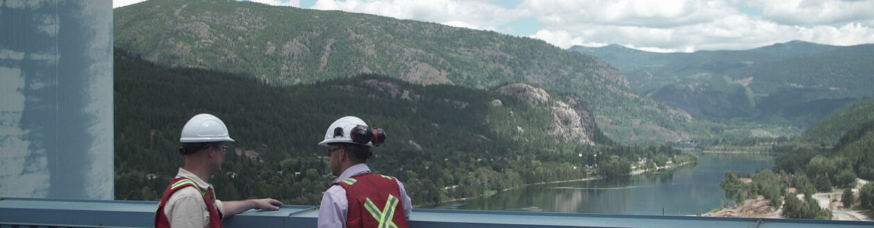 Zwei Mitarbeiter von Mercer Celgar überblicken den Nelson River in British Columbia, Kanada, vom Dach der Zellstofffabrik