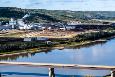 Landschaftsaufnahme vom Zellstoffwerke Mercer Peace River. Im Vordergrund eine Brücke , die über den Peace River führt.